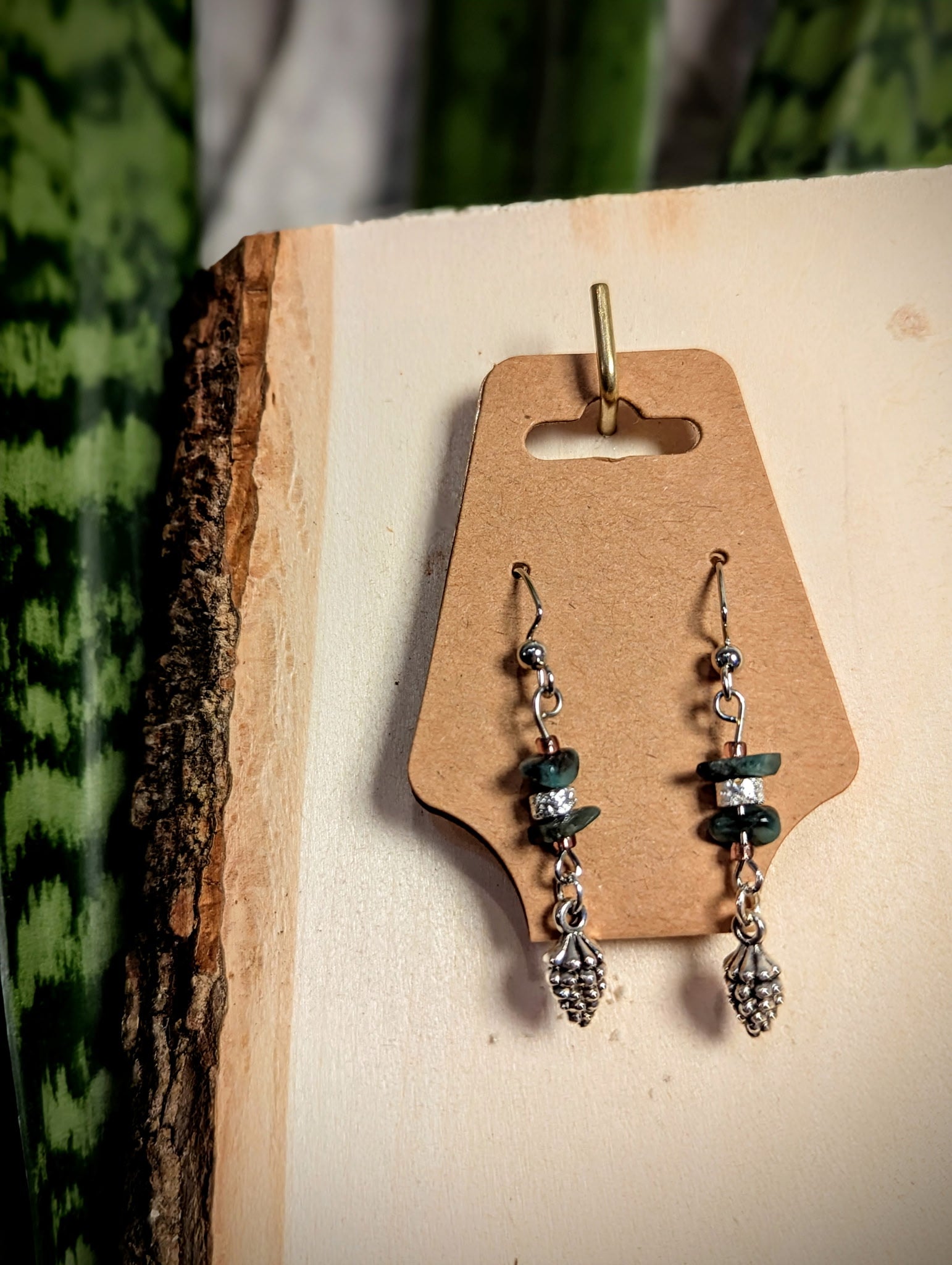 silver pinecone charms on the end of green and silver natural themed earrings